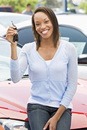 Woman smiling holding keys up to new car
