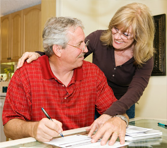 Husband & wife signing a check